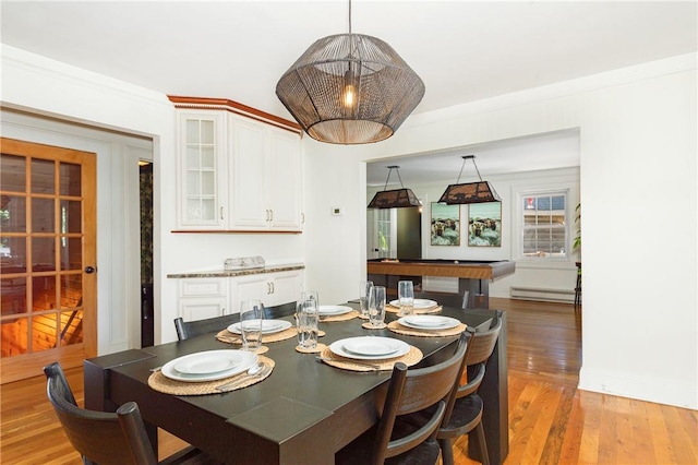 dining area with light wood-type flooring, crown molding, billiards, and a baseboard radiator