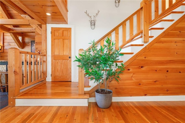 stairway with hardwood / wood-style floors and wooden ceiling