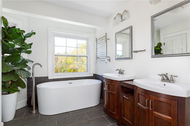 bathroom with a bathing tub, tile patterned flooring, vanity, and radiator heating unit