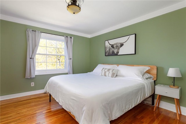 bedroom with crown molding and hardwood / wood-style flooring