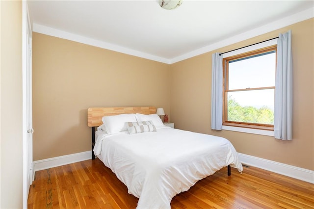 bedroom featuring hardwood / wood-style floors and crown molding