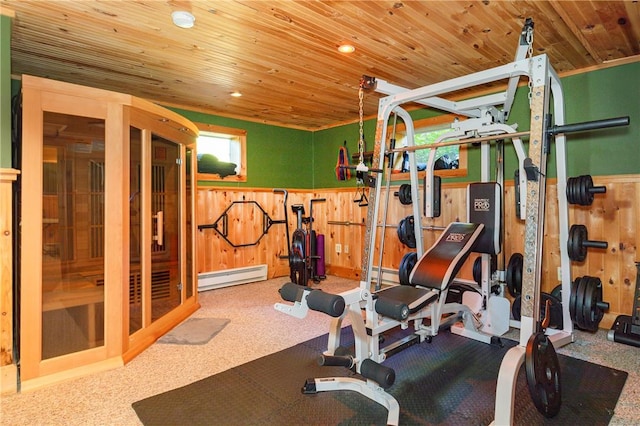 workout area featuring carpet floors, wooden ceiling, a baseboard heating unit, and wood walls