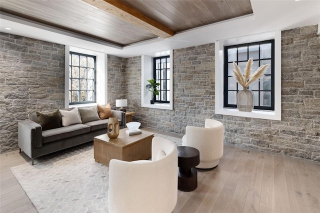 living room featuring beam ceiling, light hardwood / wood-style floors, and wooden ceiling