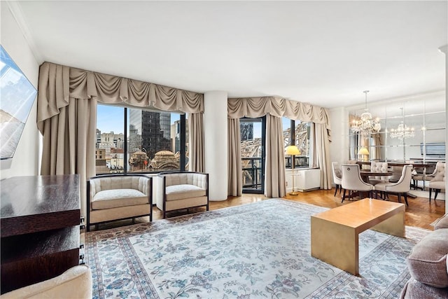 living room with hardwood / wood-style flooring, an inviting chandelier, and ornamental molding