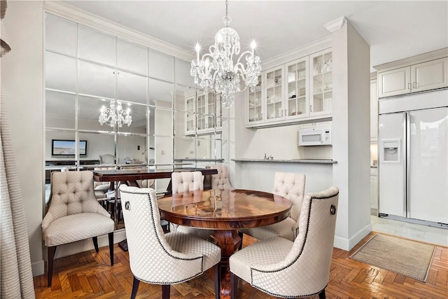 dining room with parquet floors, an inviting chandelier, and ornamental molding