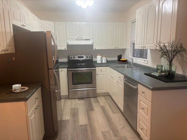 kitchen with appliances with stainless steel finishes, light hardwood / wood-style flooring, white cabinetry, and sink