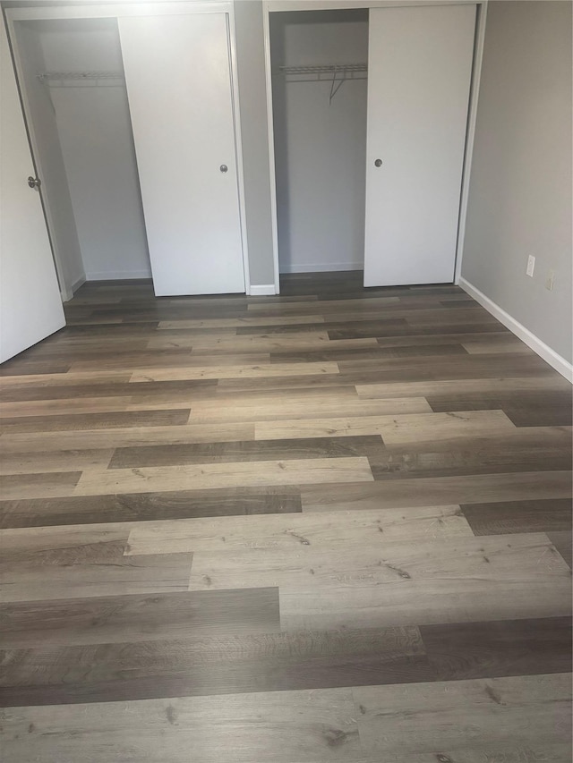 unfurnished bedroom with dark wood-type flooring