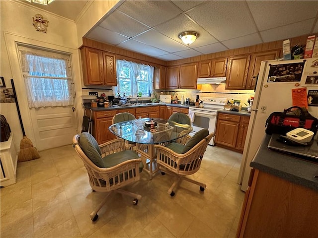 kitchen featuring a paneled ceiling and white appliances