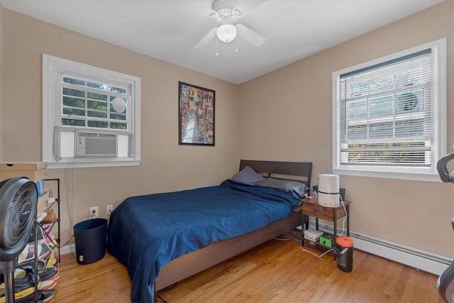 bedroom with ceiling fan, cooling unit, a baseboard heating unit, and light wood-type flooring