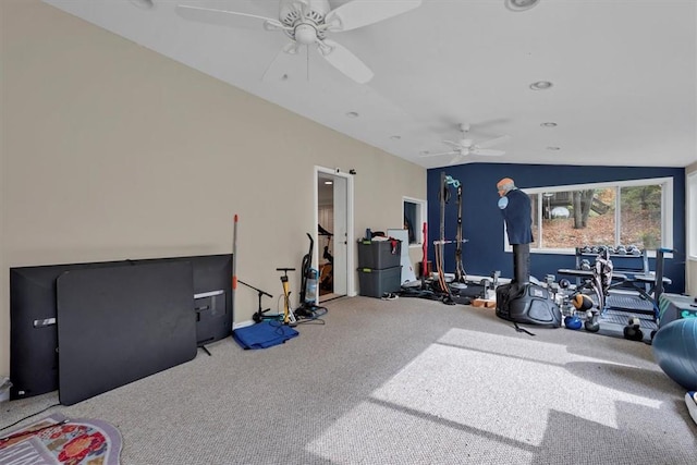 exercise room with carpet, vaulted ceiling, and ceiling fan