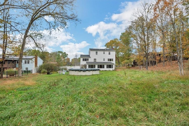 rear view of property with a covered pool