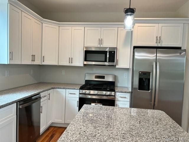 kitchen featuring white cabinetry, dark hardwood / wood-style flooring, stainless steel appliances, and light stone counters