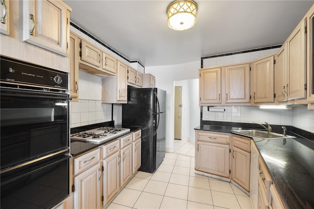 kitchen featuring light brown cabinets, black appliances, sink, decorative backsplash, and light tile patterned flooring