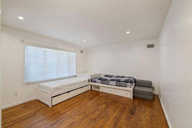 bedroom with dark wood-type flooring