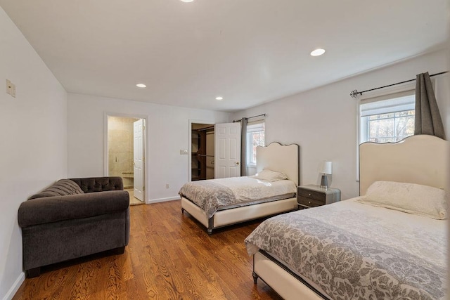 bedroom with connected bathroom and hardwood / wood-style flooring