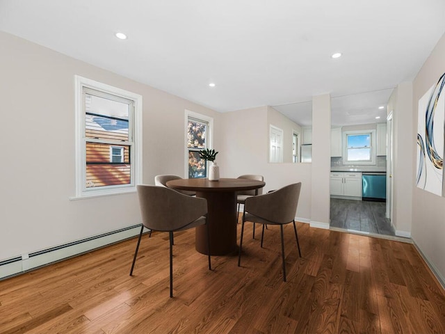 dining space with hardwood / wood-style floors and baseboard heating