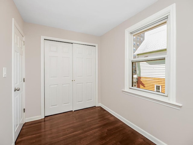 unfurnished bedroom featuring dark hardwood / wood-style floors and a closet