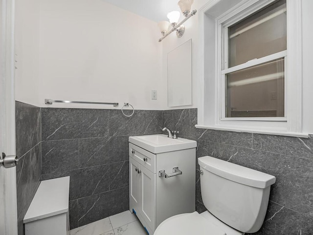 bathroom with vanity, tile walls, and toilet