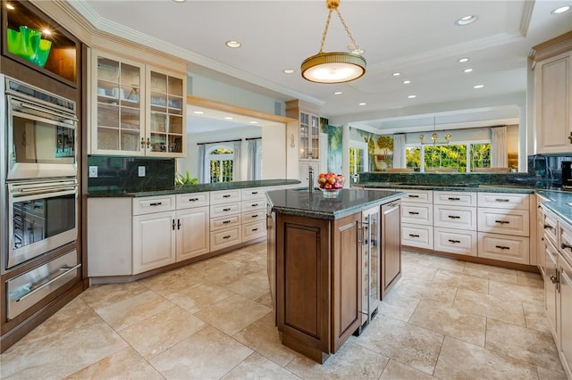 kitchen with kitchen peninsula, stainless steel double oven, tasteful backsplash, and a center island with sink