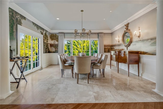 dining room with a notable chandelier, ornate columns, and crown molding