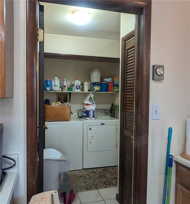 laundry area with independent washer and dryer and light tile patterned floors