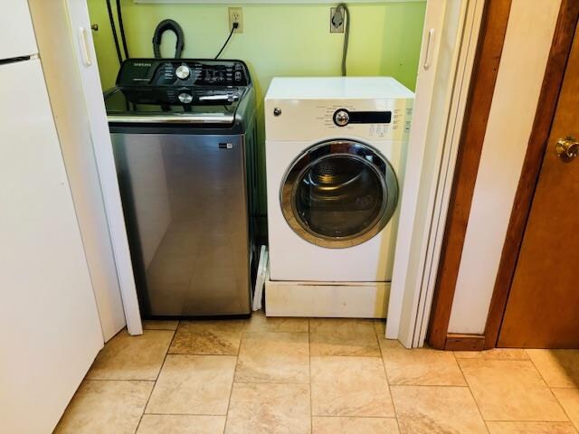 washroom featuring washing machine and clothes dryer and light tile patterned floors