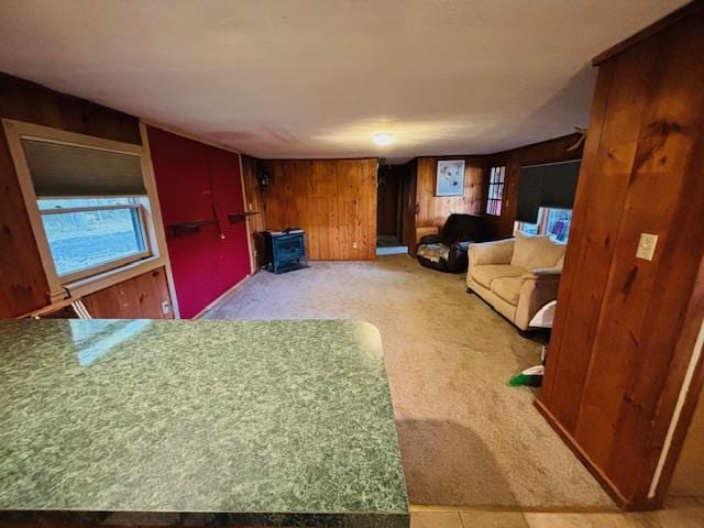 carpeted living room with wood walls