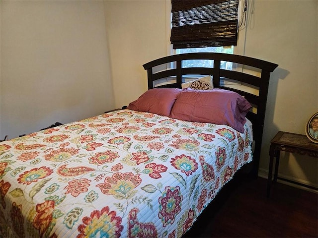 bedroom with dark hardwood / wood-style flooring