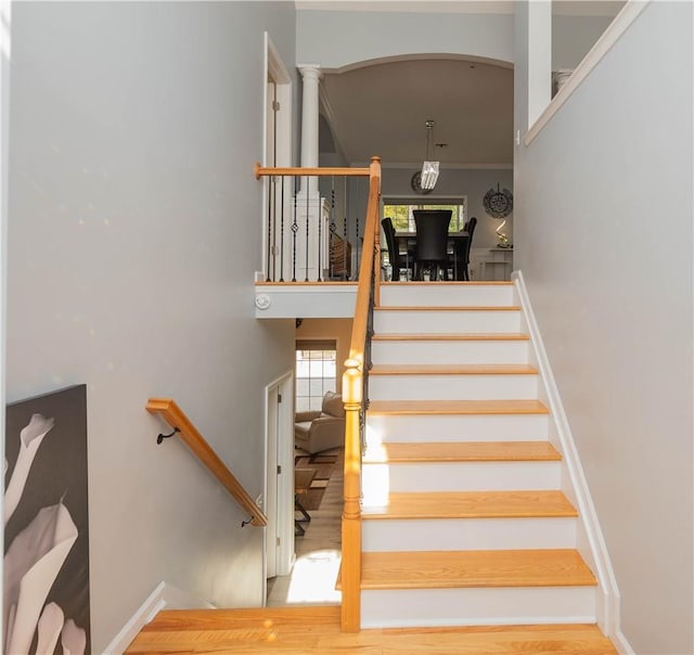 stairway with hardwood / wood-style floors and ornamental molding