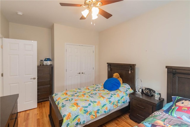 bedroom featuring ceiling fan, light wood-type flooring, and a closet