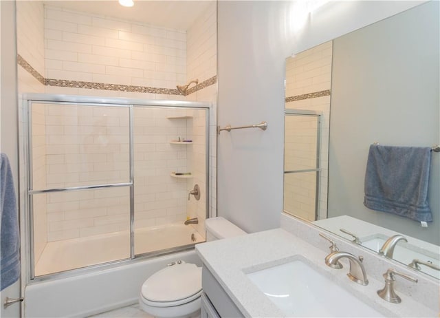 full bathroom featuring vanity, bath / shower combo with glass door, and toilet