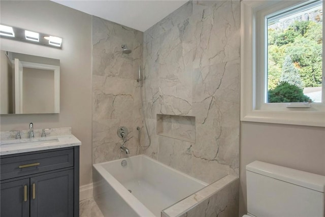 full bathroom featuring tiled shower / bath combo, a healthy amount of sunlight, toilet, and vanity