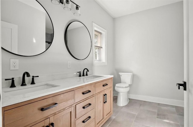 bathroom with tile patterned flooring, vanity, and toilet