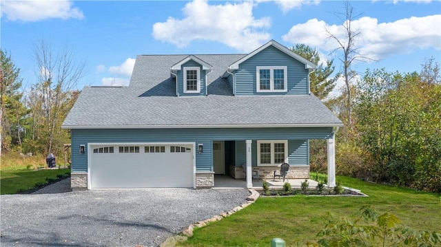 view of front of house with covered porch, a front yard, and a garage