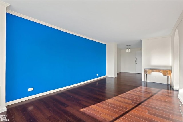 spare room with dark hardwood / wood-style flooring and ornamental molding