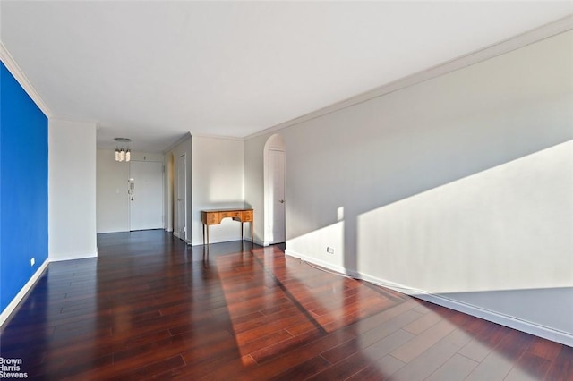 empty room with dark hardwood / wood-style flooring and ornamental molding