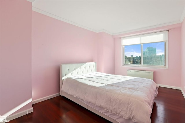 bedroom with crown molding and dark hardwood / wood-style flooring