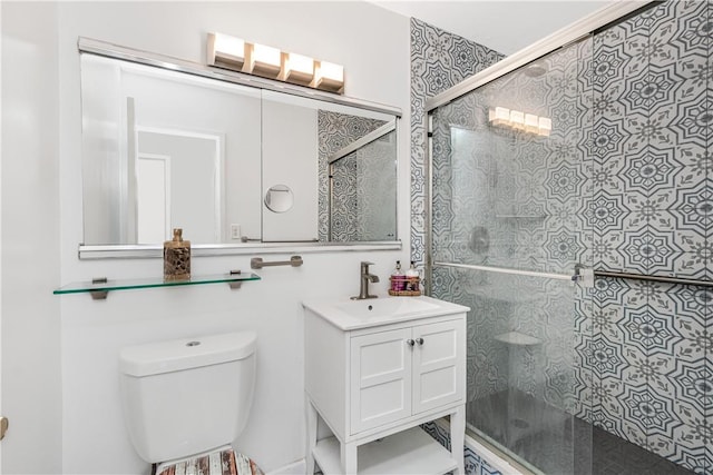 bathroom featuring vanity, toilet, and a shower with shower door