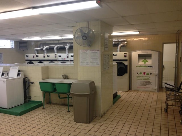 interior space with washer and clothes dryer, light tile patterned floors, and sink