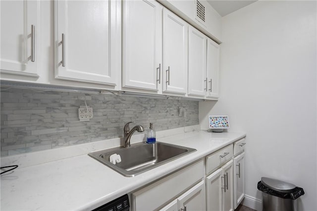 kitchen featuring white cabinets, backsplash, and sink