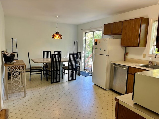 kitchen featuring pendant lighting, white fridge, stainless steel dishwasher, and sink