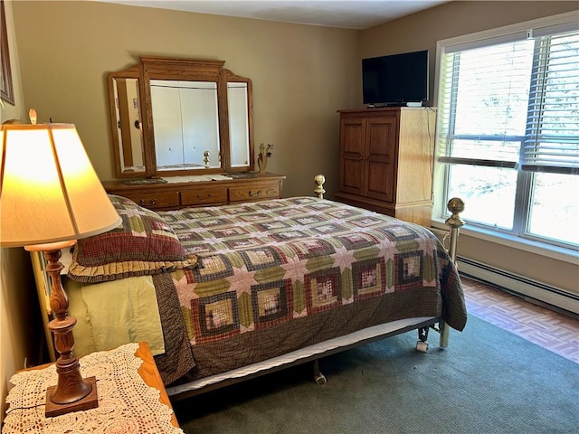 bedroom featuring baseboard heating and parquet flooring