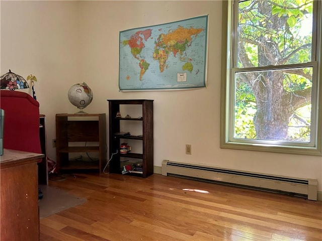 interior space with plenty of natural light, light hardwood / wood-style floors, and a baseboard heating unit