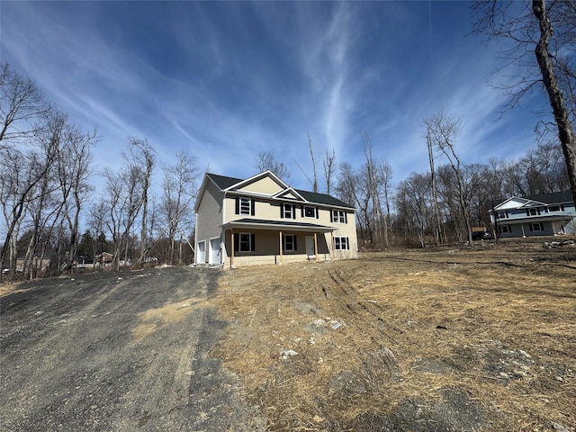 view of front of property with a garage, a porch, and driveway