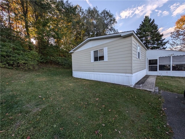 view of home's exterior featuring a lawn and a sunroom