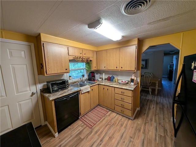 kitchen with black appliances, light hardwood / wood-style floors, sink, and a textured ceiling