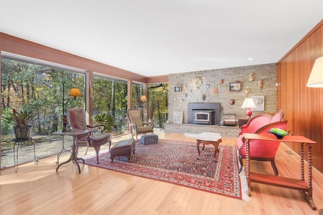 living room with wood walls, light wood-type flooring, and a wood stove