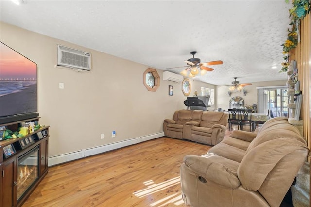 living room with a wall mounted AC, ceiling fan, a baseboard radiator, and light hardwood / wood-style floors