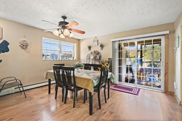 dining area with ceiling fan, wood-type flooring, and a textured ceiling