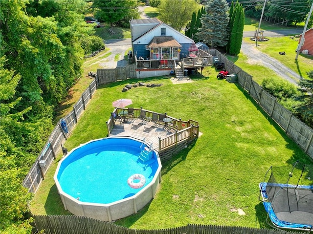 view of swimming pool featuring a gazebo, a lawn, a deck, and a trampoline